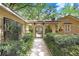 Arched walkway leading to courtyard with lush, manicured bushes and black metal gate at 2503 Victarra Cir, Lutz, FL 33559