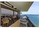 Relaxing balcony featuring waterfront views, tile flooring, outdoor seating, and sliding glass doors at 2700 Bayshore Blvd # 11405, Dunedin, FL 34698