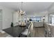 Bright dining area with crystal chandelier flows into a cozy living room with balcony access at 2700 Bayshore Blvd # 11405, Dunedin, FL 34698
