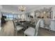 Open-concept dining area with modern chandelier, opening up to the kitchen and balcony views at 2700 Bayshore Blvd # 11405, Dunedin, FL 34698