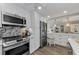 Bright kitchen with stainless appliances, white cabinetry, quartz countertops, and pendant lighting at 2700 Bayshore Blvd # 11405, Dunedin, FL 34698