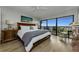 Bright main bedroom with balcony access, serene views, hardwood floors, and warm lighting at 2700 Bayshore Blvd # 11405, Dunedin, FL 34698