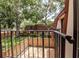 This image shows a balcony with a metal railing overlooking a fenced yard with green grass and mature trees at 2725 11Th Ct, Palm Harbor, FL 34684