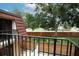 A balcony with metal railing offers a view of a grassy fenced yard and mature trees, adding privacy and charm at 2725 11Th Ct, Palm Harbor, FL 34684