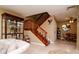 Open living room featuring a ceiling fan, staircase, and decorative display cabinet at 2725 11Th Ct, Palm Harbor, FL 34684