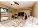 Bright living room featuring a ceiling fan, television, and sliding glass door access to the patio at 2725 11Th Ct, Palm Harbor, FL 34684