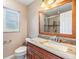 Well-lit bathroom featuring a wood framed mirror over a granite countertop vanity and updated shower at 2911 Pemberton Creek Dr, Seffner, FL 33584