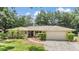 Charming single-story home with a well-maintained lawn, mature trees, and a two-car garage at 2911 Pemberton Creek Dr, Seffner, FL 33584