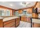 Kitchen featuring wooden cabinetry, tile backsplash, black appliances, an island and white tile floors at 2911 Pemberton Creek Dr, Seffner, FL 33584