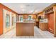 Kitchen featuring wooden cabinetry, tile backsplash, black appliances, an island and white tile floors at 2911 Pemberton Creek Dr, Seffner, FL 33584