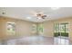 Bright living room featuring wood flooring, a ceiling fan, three windows, and sliding glass doors at 2911 Pemberton Creek Dr, Seffner, FL 33584