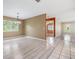 Open-concept Living Room with grey laminate flooring, large windows with view of trees at 2911 Pemberton Creek Dr, Seffner, FL 33584