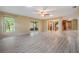 Spacious open-concept living room with light laminate flooring, a ceiling fan and access to the kitchen at 2911 Pemberton Creek Dr, Seffner, FL 33584