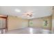 Spacious living room with wood flooring, ceiling fan, two windows, and a front door at 2911 Pemberton Creek Dr, Seffner, FL 33584