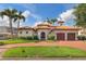 Elegant Mediterranean home with a red tile roof, brick driveway, arched entry gate and lush landscaping at 301 Bayview Ne Dr, St Petersburg, FL 33704