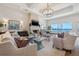 Bright and airy living room with a fireplace, chandelier, and expansive water views at 301 Bayview Ne Dr, St Petersburg, FL 33704