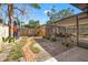 Backyard view showcases a covered patio, lush landscaping, and decorative brick walkway at 310 55Th S Ave, St Petersburg, FL 33705