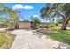 Spacious driveway leading to a well-maintained home with verdant lawn and mature trees at 310 55Th S Ave, St Petersburg, FL 33705
