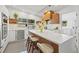 Modern kitchen with sleek white cabinetry, an island with seating, and stainless steel appliances at 310 55Th S Ave, St Petersburg, FL 33705