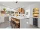 Modern kitchen with sleek white cabinetry, an island with seating, and stainless steel appliances at 310 55Th S Ave, St Petersburg, FL 33705