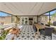 Inviting covered patio with stylish tile flooring, a dining table, and cozy seating area with mounted TV at 310 55Th S Ave, St Petersburg, FL 33705