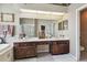 Bathroom vanity with dual sinks, dark wood cabinetry, a large mirror, and bright recessed lighting at 3402 Stonebridge Trl, Valrico, FL 33596