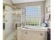 Bathroom featuring a tiled shower, soaking tub, and a window of glass blocks for bright privacy at 3402 Stonebridge Trl, Valrico, FL 33596