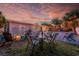 Outdoor dining on the backyard patio with a pool, fire pit, and vibrant sunset views at 3485 Floral Dr, Largo, FL 33771