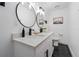 Modern bathroom featuring double vanity, sleek black fixtures, and eye-catching black and white tiled flooring at 3485 Floral Dr, Largo, FL 33771