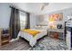 Charming bedroom with queen bed, side table, gray curtains, window, and wood-look flooring at 3485 Floral Dr, Largo, FL 33771
