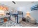 Bright bedroom boasts blue bunk beds, desk, TV, gray wood floor, and a ceiling fan at 3485 Floral Dr, Largo, FL 33771