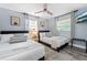 Cozy bedroom with two twin beds, ceiling fan, side table with lighting, and a wall mounted TV at 3485 Floral Dr, Largo, FL 33771