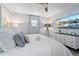 Calm bedroom with queen bed, ceiling fan, wall mounted TV, and bright natural light at 3485 Floral Dr, Largo, FL 33771