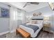 Relaxing bedroom featuring queen bed, accent bench, ceiling fan, and light-filled window with white curtains at 3485 Floral Dr, Largo, FL 33771