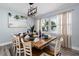 Bright dining room features seating for eight, stylish lighting, and beach-themed artwork at 3485 Floral Dr, Largo, FL 33771