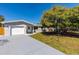 Charming single-story home with attached garage, lush lawn, and mature tree at 3485 Floral Dr, Largo, FL 33771