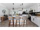 Beautiful kitchen featuring stainless appliances, white cabinets, island seating, and stylish lighting at 3485 Floral Dr, Largo, FL 33771