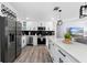 Modern kitchen with stainless steel appliances, white cabinets, and a spacious island with seating at 3485 Floral Dr, Largo, FL 33771