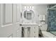 Bathroom with white vanity, modern lighting and blue tiled shower at 3505 Tarpon Woods Blvd # P404, Palm Harbor, FL 34685