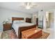 Well-lit bedroom with a bed, dresser, and a peek into the en-suite bathroom at 3505 Tarpon Woods Blvd # P404, Palm Harbor, FL 34685