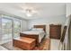 Comfortable primary bedroom with neutral walls, ceiling fan, and sliding doors with bright natural light at 3505 Tarpon Woods Blvd # P404, Palm Harbor, FL 34685