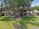 Townhomes with private patios, green lawn, and a mature shade tree at 3505 Tarpon Woods Blvd # P404, Palm Harbor, FL 34685
