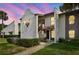 Inviting condo exterior with stucco walls, red roof tiles, manicured landscaping and warm accent lighting at dusk at 3505 Tarpon Woods Blvd # P404, Palm Harbor, FL 34685