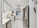 Bright white kitchen with stainless appliances, marble floors, and view into the living room at 3505 Tarpon Woods Blvd # P404, Palm Harbor, FL 34685
