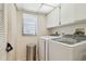 Bright laundry room with modern washer and dryer and storage cabinets at 3505 Tarpon Woods Blvd # P404, Palm Harbor, FL 34685