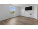 Bright bedroom featuring wood-look floors, a large window, and a wall-mounted TV at 3580 38Th S Ave # 95, St Petersburg, FL 33711