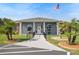 Community clubhouse entrance featuring American flag, palm trees, and manicured landscaping at 37420 Teaberry Loop, Zephyrhills, FL 33542