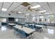 A spacious community room has large tables, chairs and many windows for natural light at 37420 Teaberry Loop, Zephyrhills, FL 33542