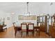 Dining room features a wooden table, upholstered chairs, light fixture, and wood floors at 37420 Teaberry Loop, Zephyrhills, FL 33542