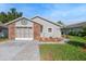 Charming single story home with brick accent, screened garage, colorful landscaping, and well maintained lawn at 37420 Teaberry Loop, Zephyrhills, FL 33542